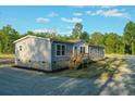 Home with gray siding and white trim, front porch, gravel driveway, and green surroundings at 526 Branch Bend Way, Cross, SC 29436