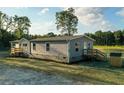 New home with gray siding, white trim, front and rear decks, and a gravel driveway at 526 Branch Bend Way, Cross, SC 29436