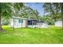 Expansive backyard with green grass, swing set, and mature trees surrounding this cozy home at 538 Castlebury Rd, Walterboro, SC 29488
