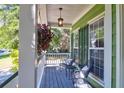 Relaxing covered front porch features chairs and hanging flower basket at 794 Hunt Club Run, Charleston, SC 29414