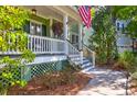Charming front porch with hanging flower baskets, stairs, and an American flag at 794 Hunt Club Run, Charleston, SC 29414