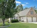 Inviting home with lush lawn and mature tree offering shade, plus a convenient two-car garage enhances curb appeal at 8496 Roanoke Dr, North Charleston, SC 29406
