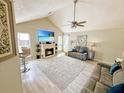 Bright living room features a cozy fireplace, vaulted ceilings, ceiling fan, and wood-look floors for a modern touch at 8496 Roanoke Dr, North Charleston, SC 29406
