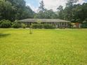 One story brick home showing the expansive green lawn, front of the house, and some trees at 8719 Jefferies Hwy, Walterboro, SC 29488