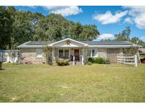 Brick ranch house with solar panels, porch, and large yard at 175 Maria Stuart Ln, Varnville, SC 29944