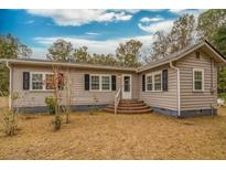 Ranch style home with brick steps, grey siding, and black shutters at 8375 Shell House Rd, Edisto Island, SC 29438