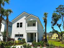 Charming two-story home with white siding, landscaping, and a detached garage at 229 Claret Cup Way, Charleston, SC 29414