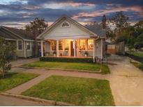 Charming single-story home featuring a cozy covered porch with a landscaped front yard and driveway at 14 Gordon St, Charleston, SC 29403
