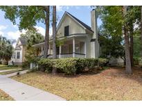 Charming light green house with a wrap-around porch and well-manicured lawn at 524 Shem Butler Ct, Charleston, SC 29414