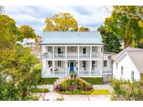 Two-story home with wraparound porch, metal roof, and landscaped yard at 436 Church St, Mount Pleasant, SC 29464