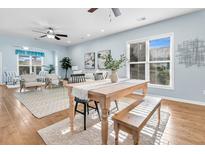 Bright dining area with wooden table and bench, hardwood floors, and access to living room at 102 Harbor Point Ct, Summerville, SC 29486