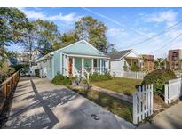 Charming light blue cottage with a white picket fence and a spacious front yard at 1071 Lockhart St, North Charleston, SC 29405