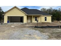 New construction home features a two-car garage and covered porch at 1085 Irving Manigault Rd, McClellanville, SC 29458