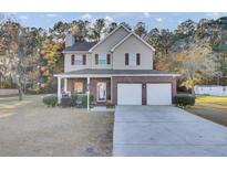 Two-story house with brick and siding, two-car garage, and a porch at 1401 Churchill Rd, Moncks Corner, SC 29461