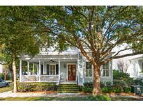 Charming light-blue house with a wrap-around porch and mature landscaping at 4 Perseverance St, Mount Pleasant, SC 29464
