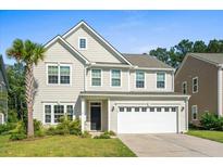 Two-story house with a white garage door and landscaping at 440 Coopers Hawk Dr, Summerville, SC 29483