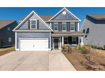 Two-story home with blue siding, white garage door, and landscaping at 602 Yellow Leaf Ln, Summerville, SC 29486