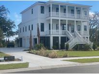 Two-story home with white siding, multiple balconies, and a three-car garage at Cir, Mount Pleasant, SC 29464
