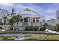 Charming white cottage with a welcoming front porch and landscaped yard at 127 Simons St, Charleston, SC 29403