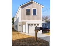 Two-story house with white and taupe siding, attached garage, and a mailbox at 1992 Groveland Ave, North Charleston, SC 29405
