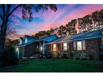 Brick ranch house with a large yard, shutters, and a two-car garage at sunset at 231 Tall Pines Rd, Ladson, SC 29456