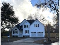 Two-story white house with two-car garage and landscaped yard at 2335 Marsh Lake Ct, Charleston, SC 29414