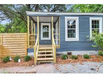 Newly renovated blue house with a modern wood fence and landscaping at 2745 W Surrey Dr, North Charleston, SC 29405