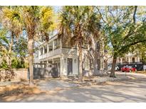 Two-story home with gray brick exterior, balconies, and gated entry at 4 Ashmead Pl, Charleston, SC 29403