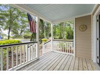 Charming front porch features a wooden deck, white railings, and a view of the street at 538 River Rd, Johns Island, SC 29455