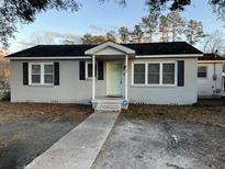 Charming ranch home with gray brick exterior, light green door, and landscaped yard at 114 Groves St, Walterboro, SC 29488
