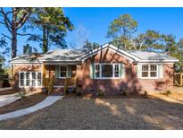 Brick home with new windows, landscaping, and a welcoming front porch at 1216 Taliaferro Ave, Charleston, SC 29412