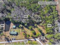 Aerial view of property showing home, detached garage, and pond at 151 Powerhouse Rd, Ridgeville, SC 29472