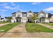 Tan and gray townhome with a 2-car garage and landscaped front yard at 162 Kirkland St, Goose Creek, SC 29445