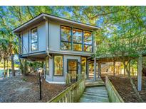 Elevated treehouse with wrap-around deck, surrounded by lush trees at 7 Dunecrest Trace, Seabrook Island, SC 29455