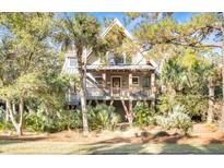 Two-story home with a charming front porch and lush landscaping at 119 Halona Ln, Kiawah Island, SC 29455