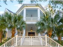 Two-story white home with a grand staircase, palm trees, and lush landscaping at 1407 Smythe St, Charleston, SC 29492