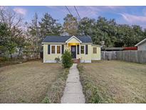 Charming yellow cottage with a well-maintained lawn and walkway at 5732 Allison Ave, Hanahan, SC 29410