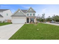 Two-story house with gray siding, white garage door, and a well-manicured lawn at 8700 Forte Dr, North Charleston, SC 29406