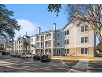 Beige apartment building with ample parking and landscaping at 130 River Landing Dr # 7208, Charleston, SC 29492