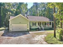 Charming one-story house with a white garage door and landscaped yard at 1374 Leisure Dr, Summerville, SC 29486