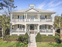 Two-story home with white brick facade, metal roof, and large front porch at 204 King George St, Charleston, SC 29492
