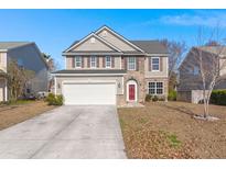 Two-story house with stone accents, a red door, and a two-car garage at 404 Glenmore Dr, Moncks Corner, SC 29461