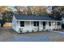 Charming white cottage with a front porch and well-maintained landscaping at 5614 Read St, North Charleston, SC 29406