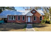 Brick home with metal roof, white door, and landscaped yard at 12240 Green Pond Hwy, Green Pond, SC 29446