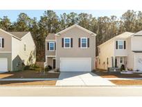 Two-story house with beige siding, white garage door, and landscaping at 135 Sunray Ln, Summerville, SC 29486