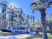 Charming ranch home with a metal roof, carport, and spacious front porch at 202 Briarwood St, Walterboro, SC 29488
