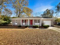 Brick ranch house with red door, covered porch, and landscaped yard at 3 Tommy Cir, Goose Creek, SC 29445