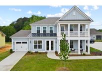 Two-story home with light blue siding, white trim, and a front porch at 351 Wappoo Trace Ln, Summerville, SC 29486