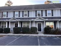 Three-unit townhome building with gray siding, white trim, and black doors at 407 Hemingway Cir, Summerville, SC 29483