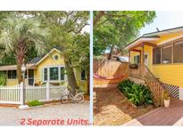 Yellow cottage with white picket fence, landscaping, and charming details at 420 E Erie Ave, Folly Beach, SC 29439